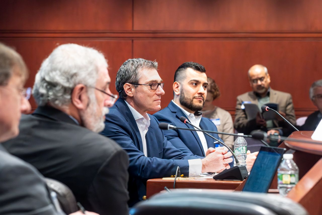 A group of men in business attire at a conference table during a meeting.