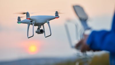 Drone pilotage. Copter flying and hovering at sunset