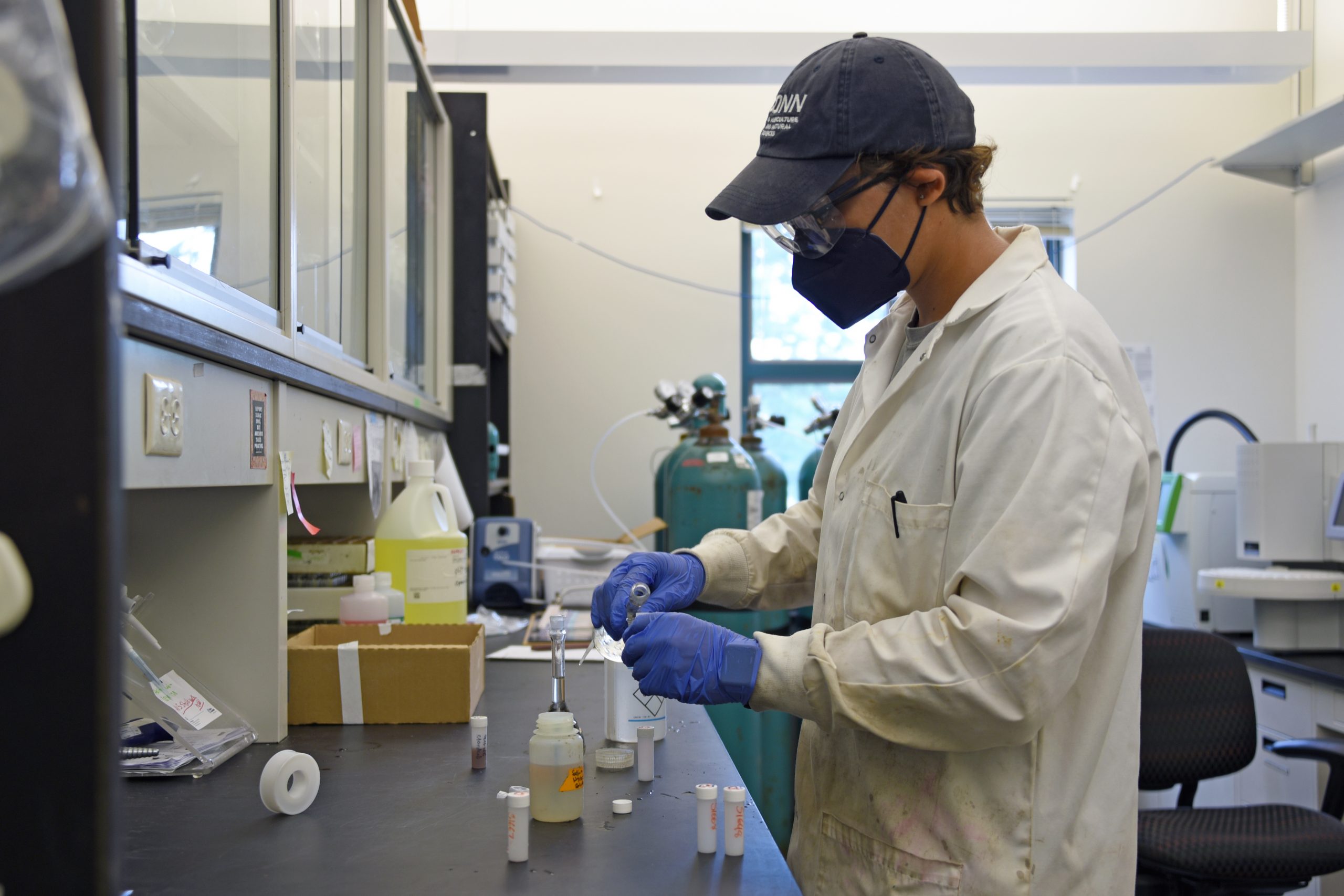 Madeline Kollegger, a graduate student in the Department of Natural Resources and the Environment in the College of Agriculture, Health and Natural Resources, tests water samples taken from wetlands at Rocky Neck State Park in Niantic in a lab in the Institute of the Environment. Aug. 11, 2022. (Jason Sheldon/UConn Photo)